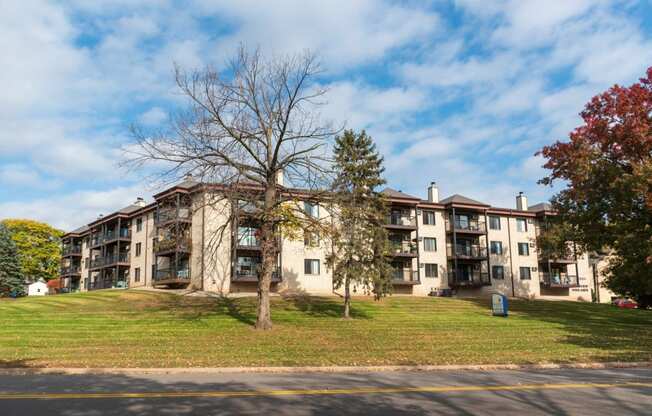 exterior view of an apartment building on a hill with a tree