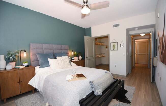 A bedroom with a bed, nightstands, and a ceiling fan.