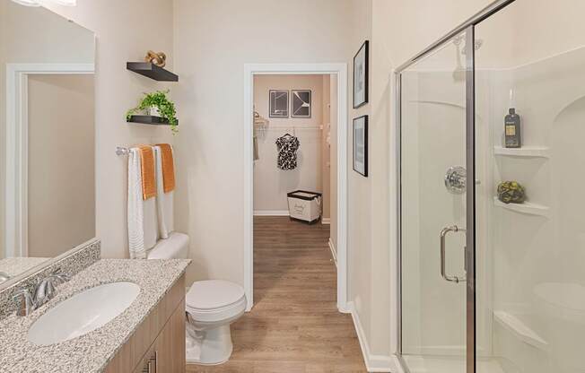 A bathroom with a toilet, sink, and shower.