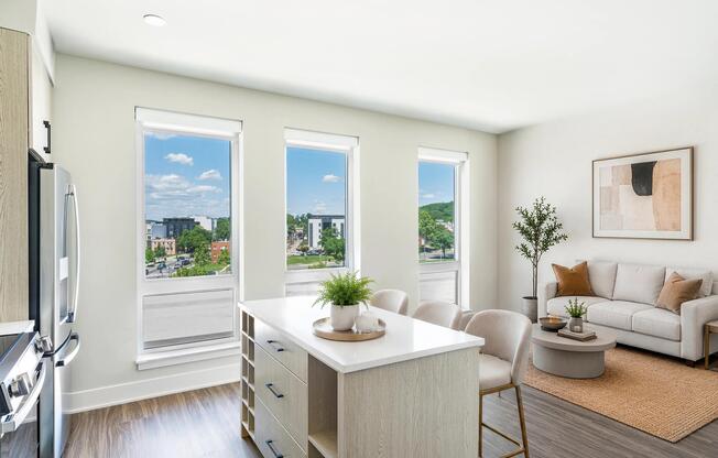 Open kitchen and living area with a central island and tall windows that bring daylight across the space and connect indoor areas seamlessly.