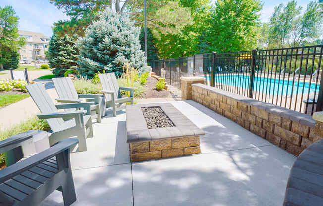 outdoor fire pit with seating outside of gated community pool