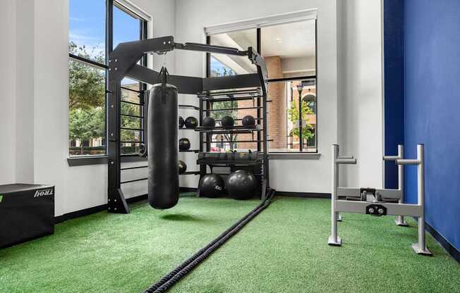 A gym with a green carpet and a punching bag.