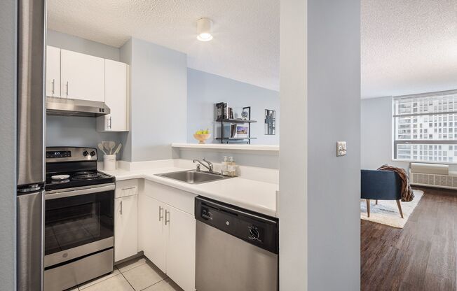 A modern kitchen with stainless steel appliances and white cabinets.