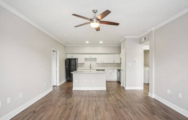 an empty living room and kitchen with a ceiling fan at The Verandah, Texas, 78726