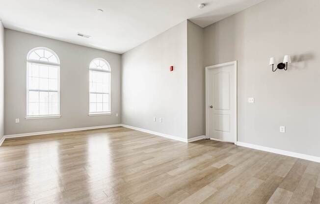 A room with wooden flooring and a white door.