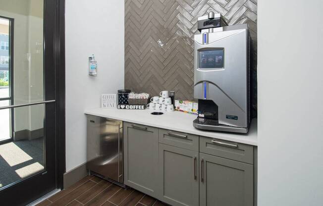 a kitchen with a coffee maker and a sink in a hotel room