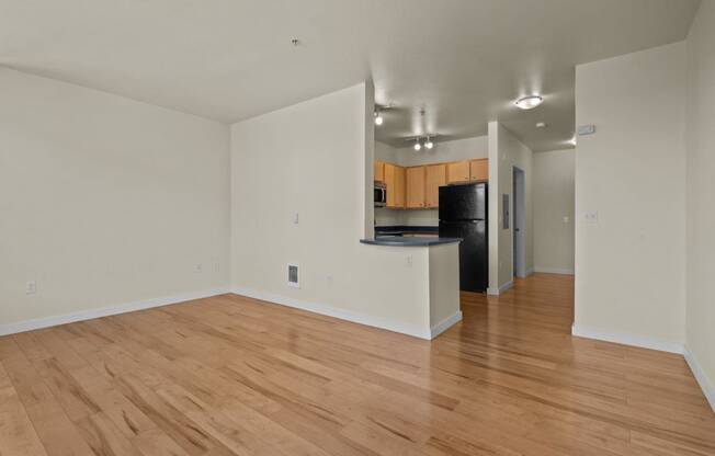 a living room and kitchen with a hard wood floor