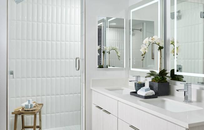 a white bathroom with a shower and a sink