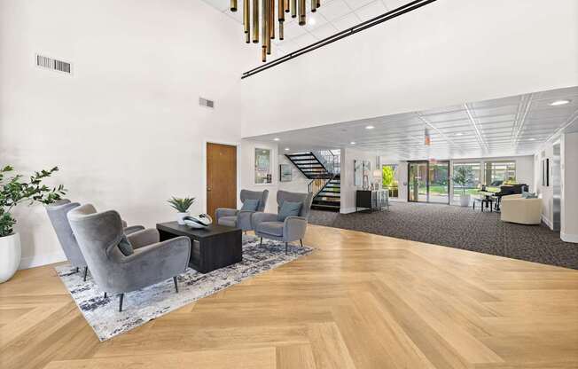 A modern office space with wooden floors and a variety of seating options.