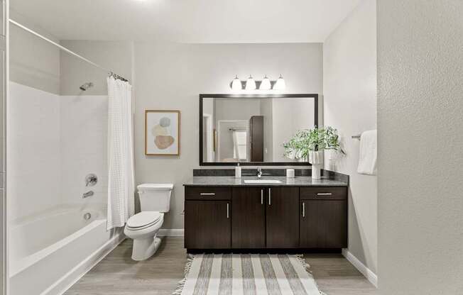 A bathroom with a white tub, sink, and toilet.