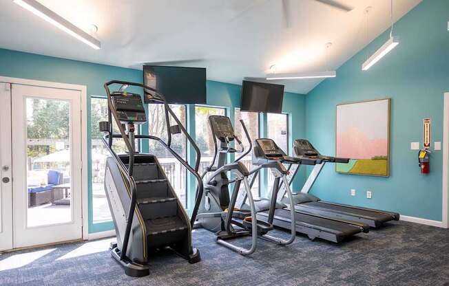 A gym with treadmills, elliptical machines, and a stair climber.