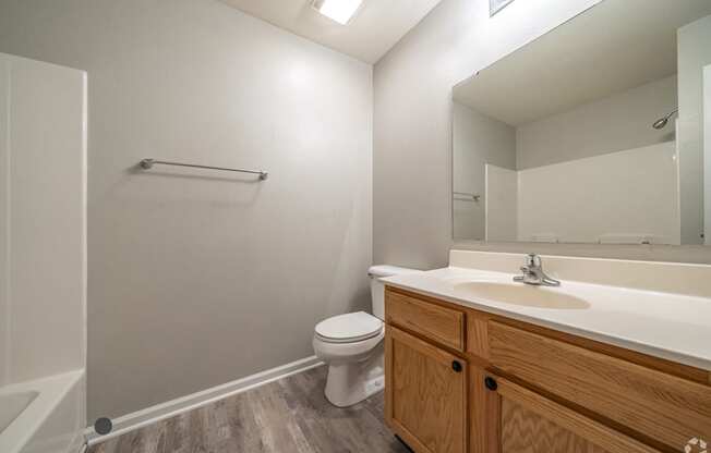 an empty bathroom with a toilet sink and mirror