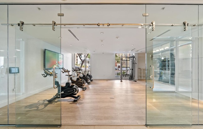 a gym with glass doors and a painting on the wall