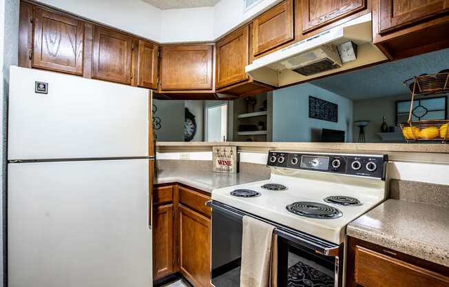 A white refrigerator is in a kitchen with wooden cabinets.