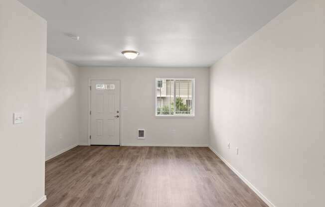 an empty living room with white walls and wood floors