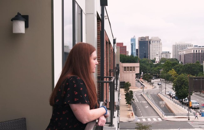 Resident standing on her balcony looking out at the view at The View at Old City Apartments in Pennsylvania