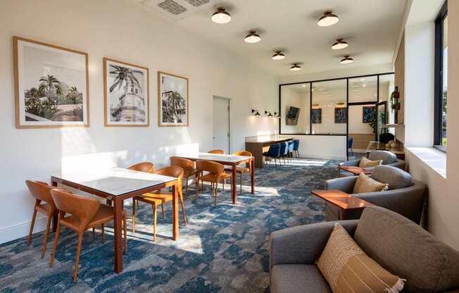 A living room with a couch, chairs, and pictures on the wall.