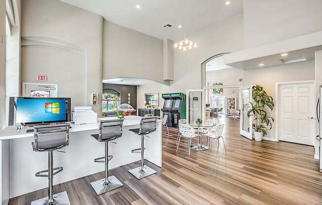 A bar area with a monitor and chairs.