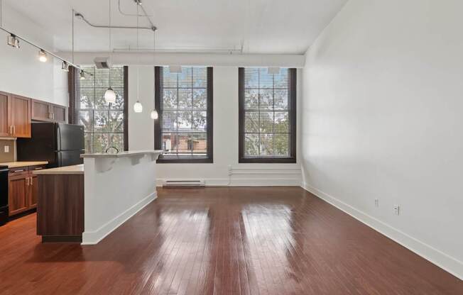 A large empty room with wooden floors and white walls.