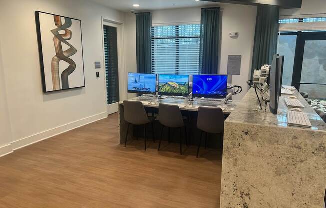 A modern office with a large desk and two monitors.