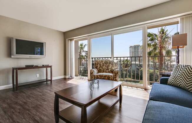 Living room with wood style floors, balcony with spectacular views, large windows