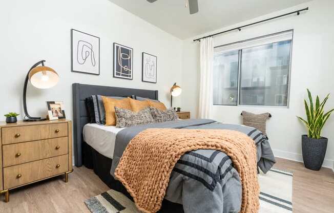 A bedroom with a bed, a dresser, and a ceiling fan.