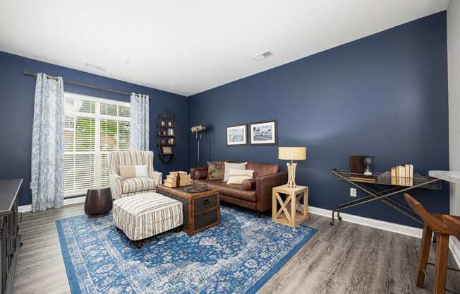 a living room with blue walls and a brown couch and chair