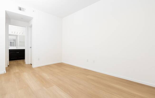 an empty room with white walls and wooden floors