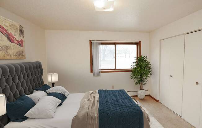 apartment bedroom with a large bed and a window