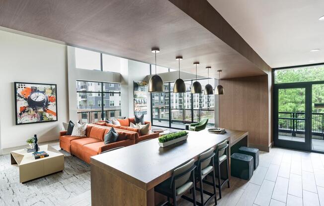 Stylish resident lounge with floor-to-ceiling windows, comfortable seating, and spaces designed for both work and relaxation.