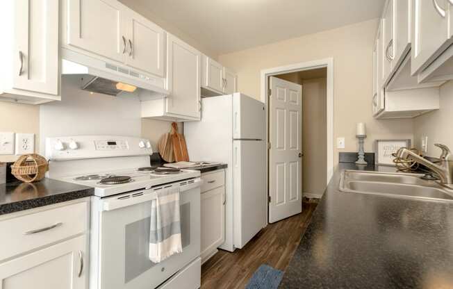 Kitchen with White Cabinets and Appliances at Three Oaks
