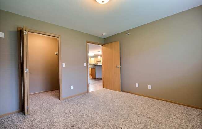 a bedroom with a closet and a door to a bathroom. Fargo, ND Urban Plains Apartments