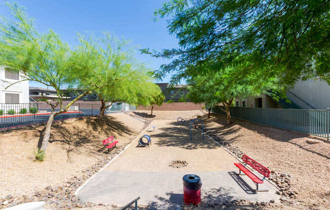 A playground with a slide, swings, and a red fire hydrant.