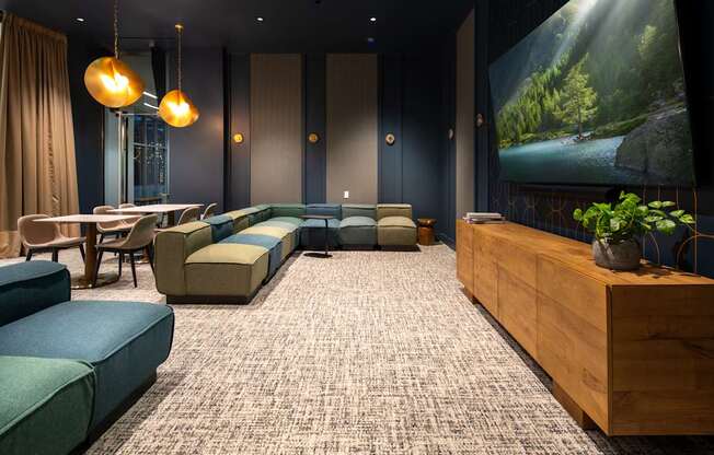 A modern living room with a large screen and comfortable seating.