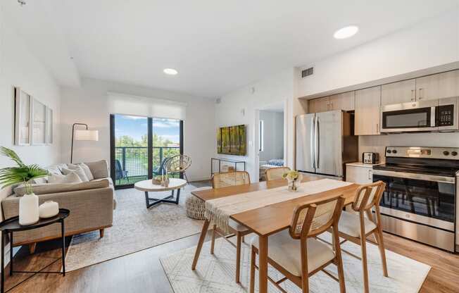 An open living room with a dining room table and a kitchen