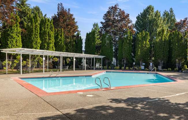 A swimming pool with a pool deck and landscaping at Clackamas Trails Apartments, Oregon, 97222