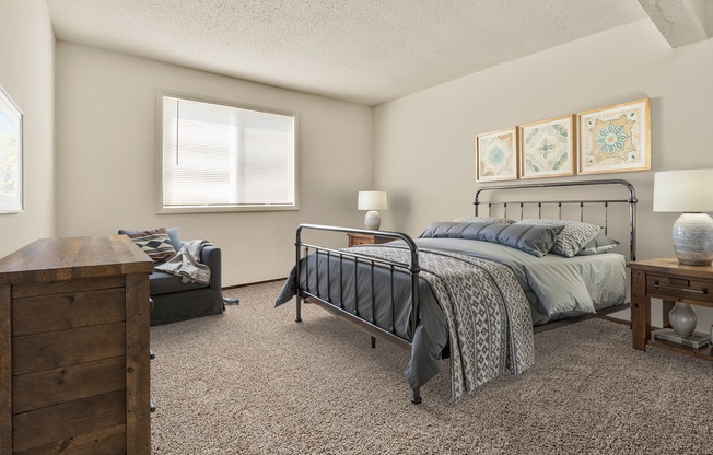A bedroom with a bed, nightstand, and dresser.