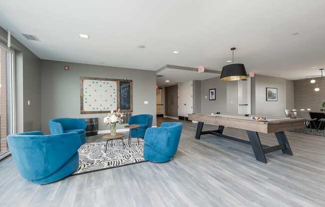 a games room with a pool table and chairs
