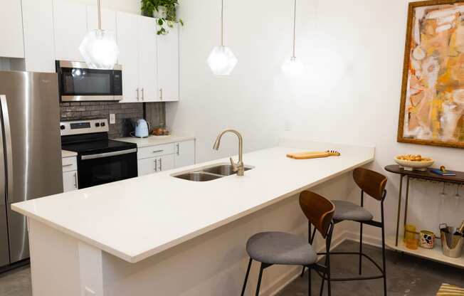 a kitchen with a white counter top and a sink  at The Lady, Columbia, SC, 29201