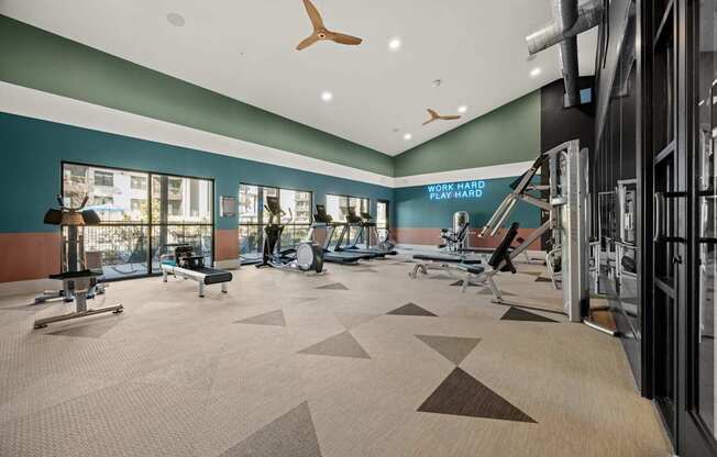 A gym with a variety of equipment including a treadmill, weights, and a bench press. at Bridge at Tech Crossing, Austin, TX
