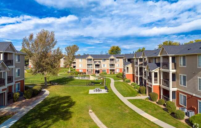 an aerial view of an apartment complex with green grass and trees