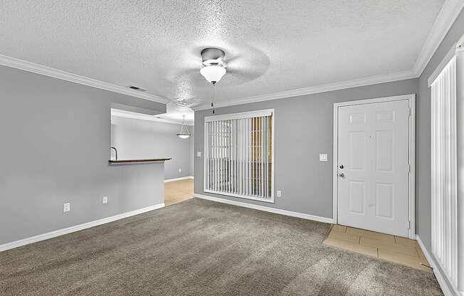 A room with a white ceiling fan and a white door.