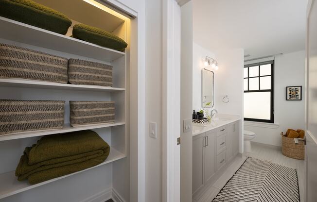 a bathroom with a sink and shelves with towels  at The Belden Stratford, Chicago, 60614