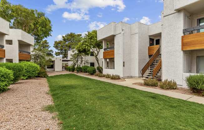 a grassy area with trees in the background at the whispering winds apartments in pearland,