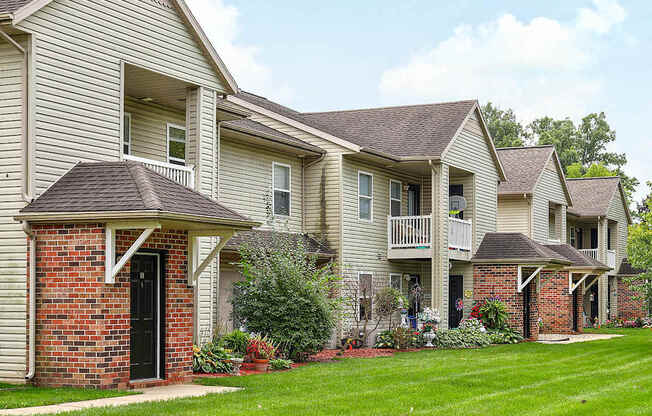 A row of houses with green lawns in front.