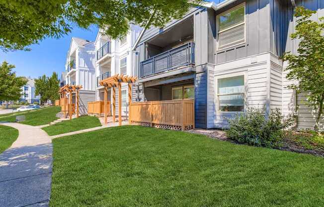 A modern apartment building with a well-maintained lawn in front.