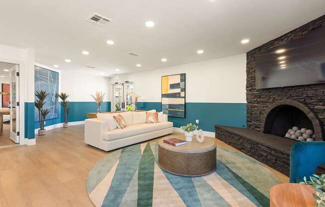 A living room with a white couch and a fireplace.