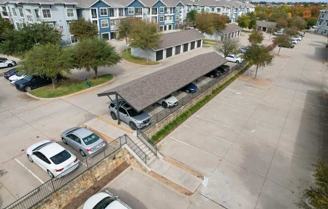 an aerial view of a parking lot and a building with cars parked