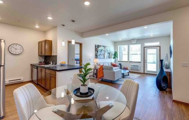 a dining room and living room area with a glass table and chairs