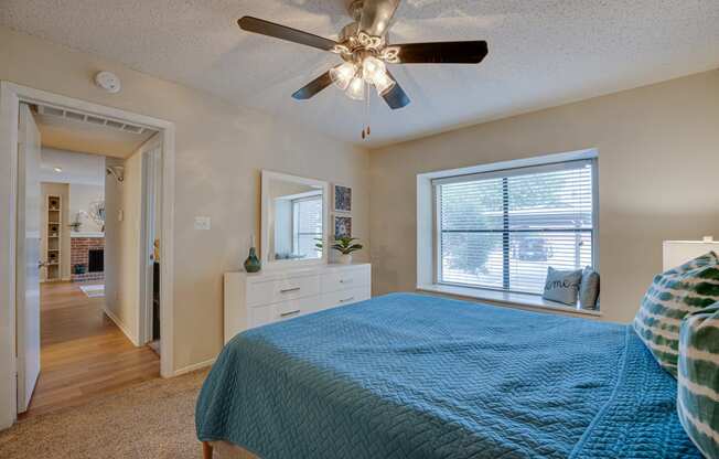 a bedroom with a bed and a ceiling fan